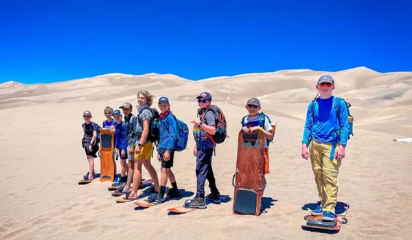 people boarding down Great Sand Dunes