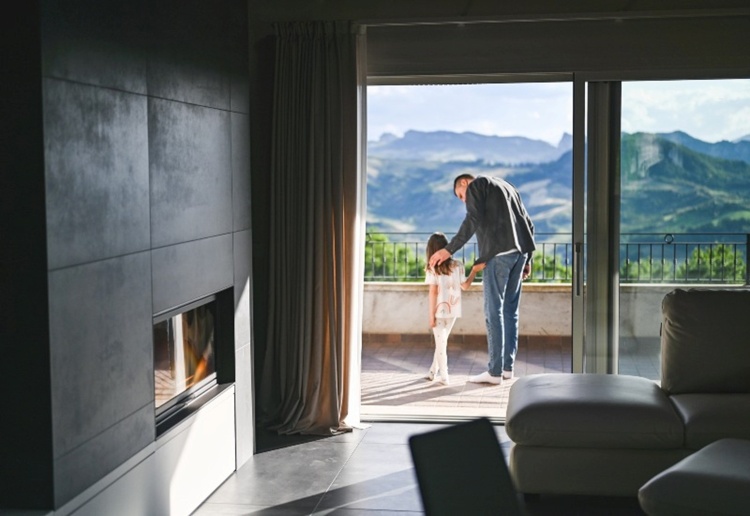 Modern living room with Colorado mountain view and family outside