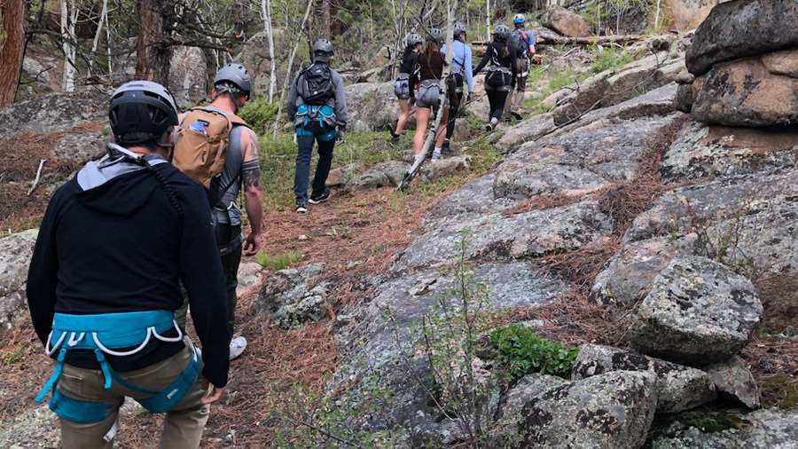 A group of people participating in an outdoor adventure, hiking near Shoshana Ranch